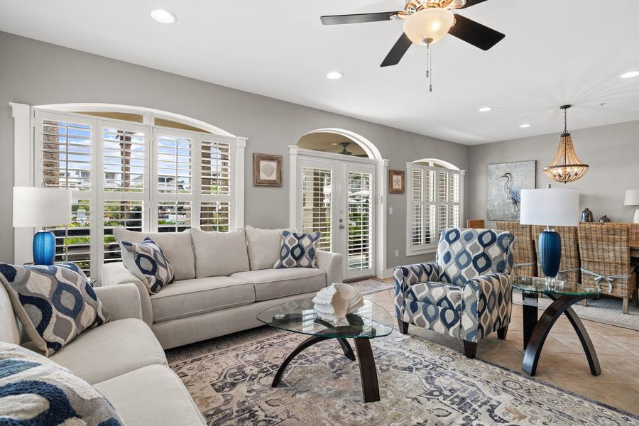 Living room with arched, shuttered windows and French doors