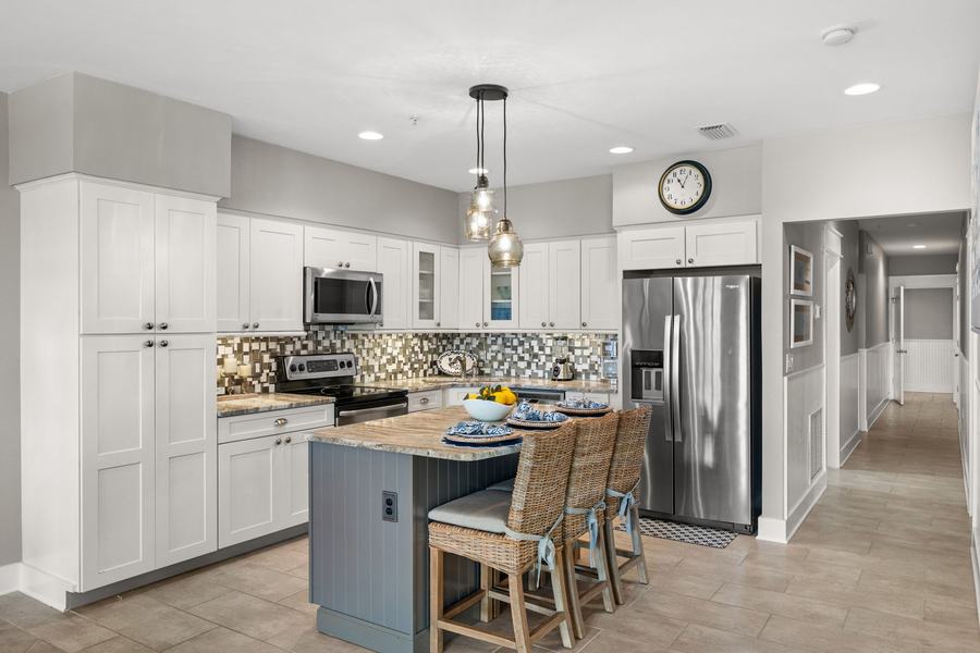 Kitchen with white cabinetry, island and stainless appliances
