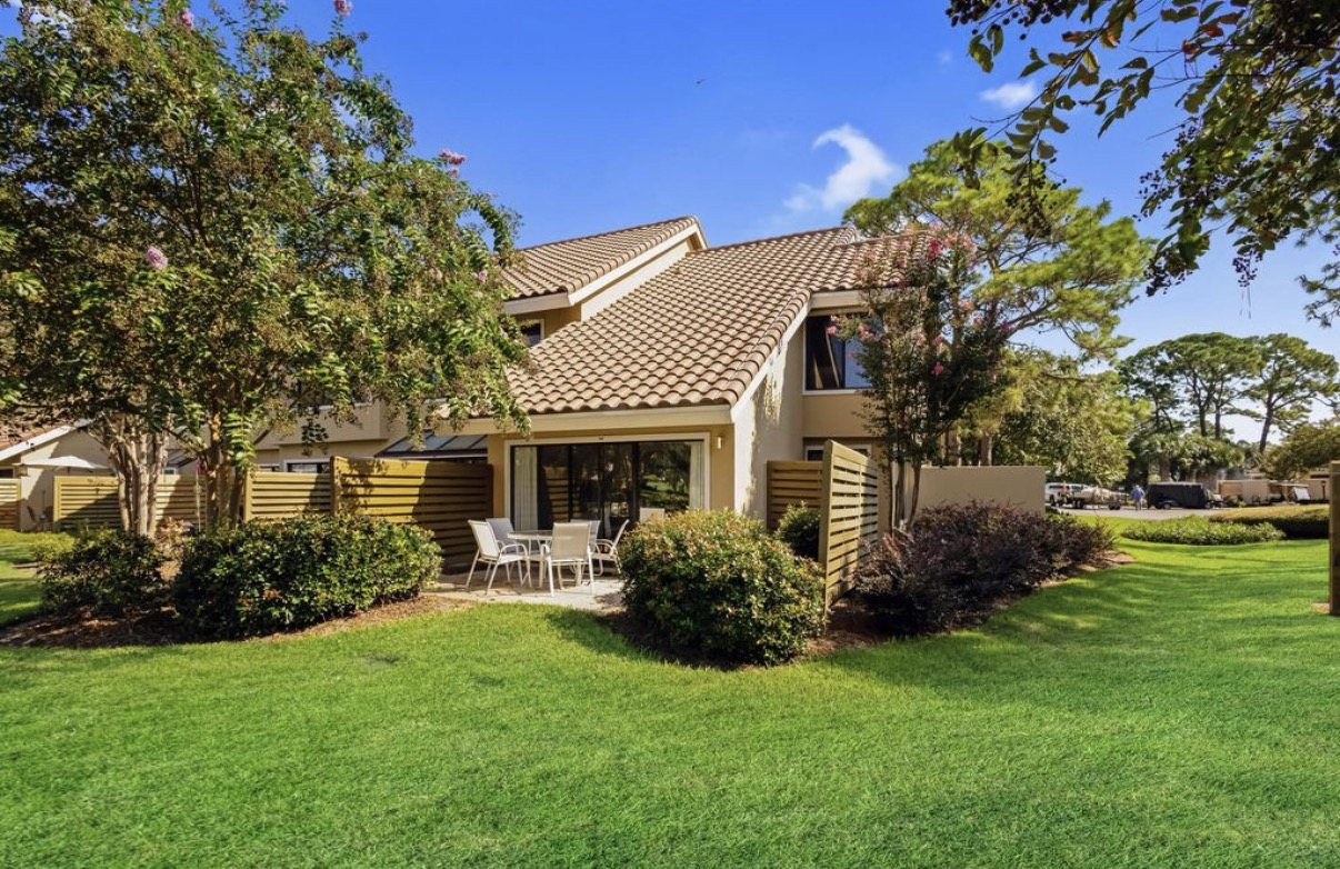 Back of 5150 Beachwalk Circle, with its patio and lawn
